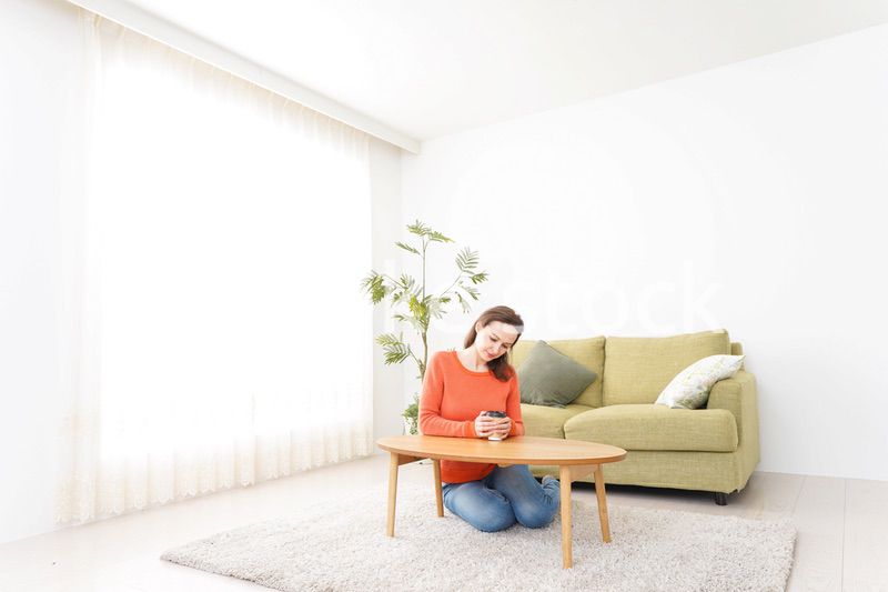 家でコーヒーを飲む若い女性