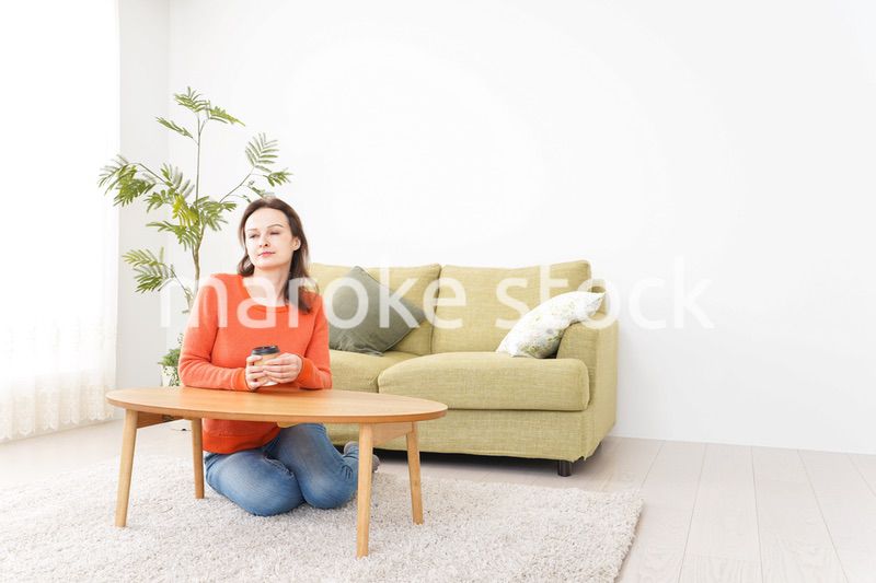 家でコーヒーを飲む若い女性