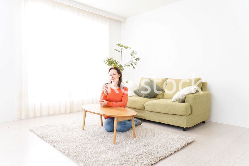 家でコーヒーを飲む若い女性