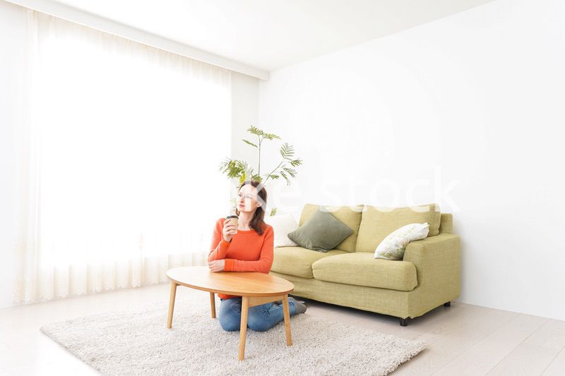 家でコーヒーを飲む若い女性