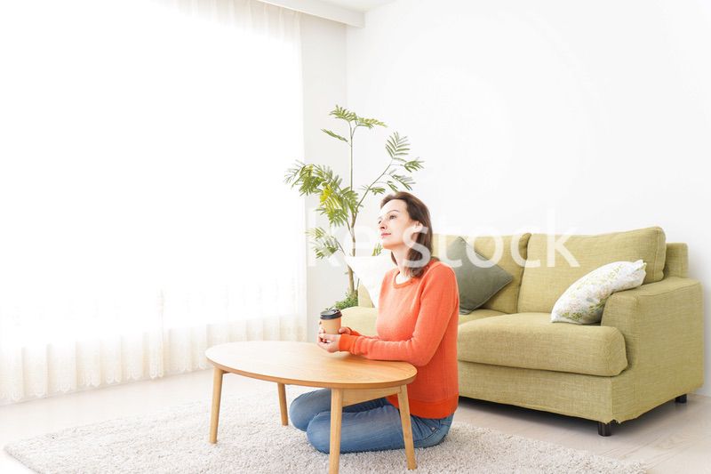 家でコーヒーを飲む若い女性