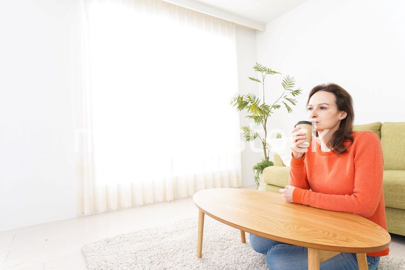 家でコーヒーを飲む若い女性