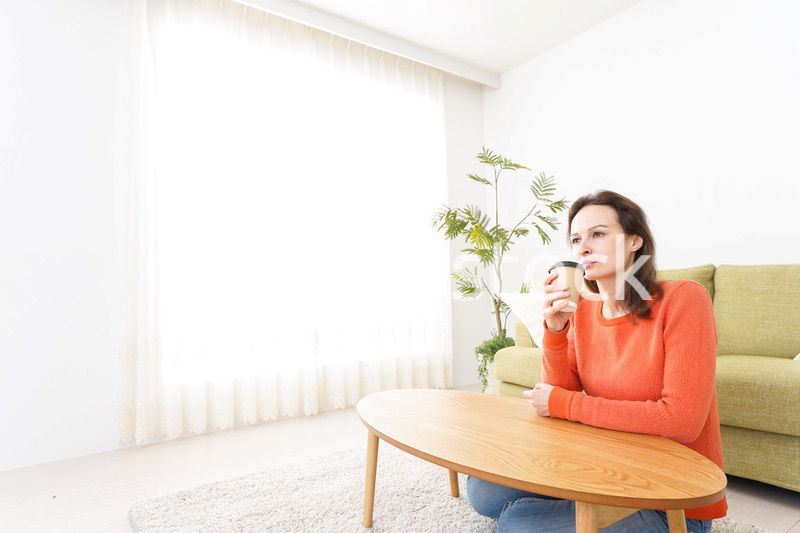 家でコーヒーを飲む若い女性