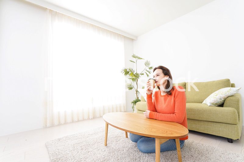 家でコーヒーを飲む若い女性