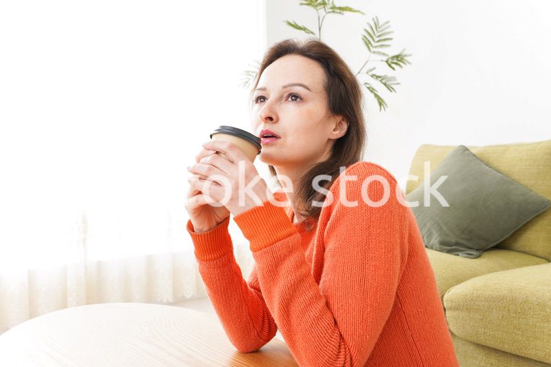 家でコーヒーを飲む若い女性