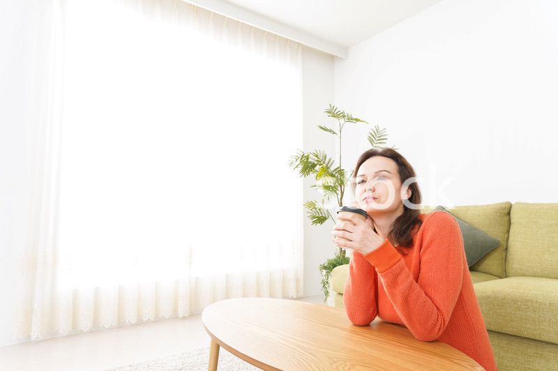 家でコーヒーを飲む若い女性