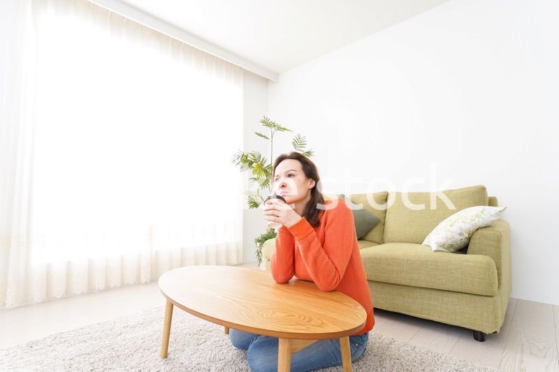 家でコーヒーを飲む若い女性