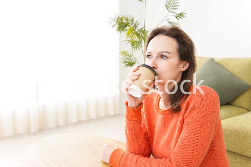 家でコーヒーを飲む若い女性