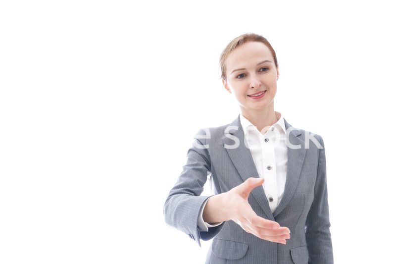 握手をするスーツを着たビジネスウーマン