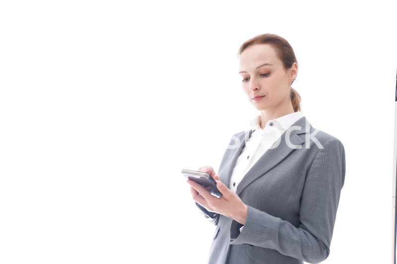 スマートフォンを使うスーツを着たビジネスウーマン