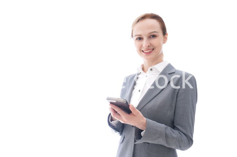 スマートフォンを使うスーツを着たビジネスウーマン