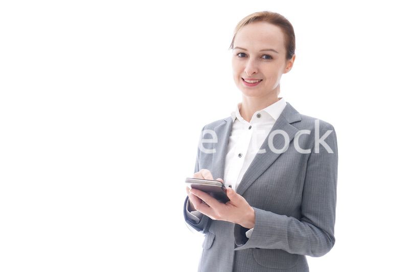 スマートフォンを使うスーツを着たビジネスウーマン