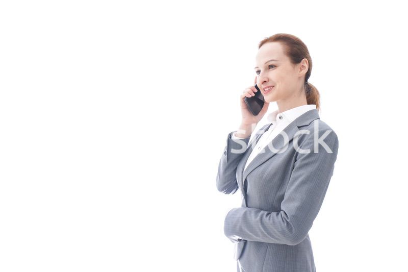 スマートフォンを使うスーツを着たビジネスウーマン