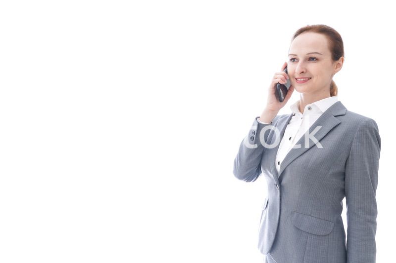 スマートフォンを使うスーツを着たビジネスウーマン