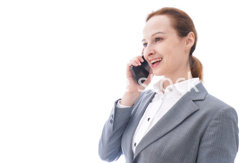 スマートフォンを使うスーツを着たビジネスウーマン