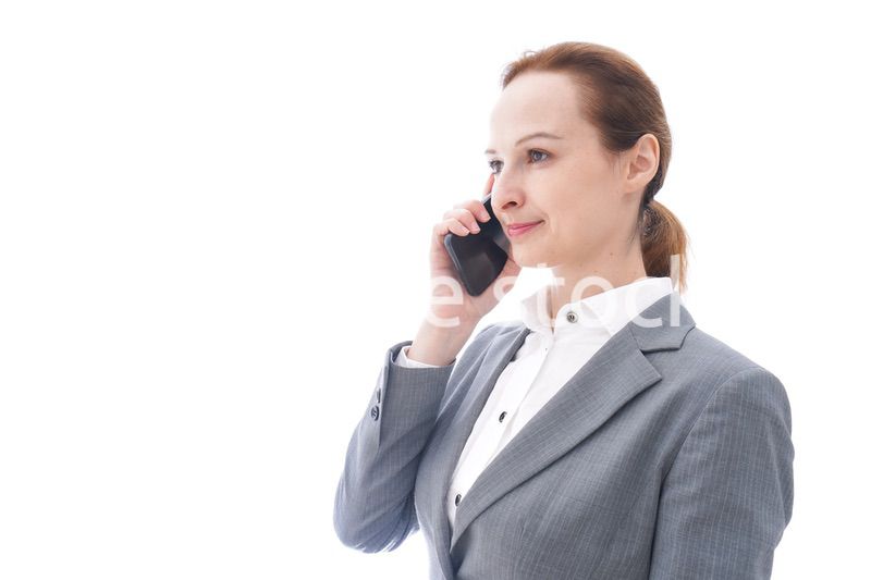 スマートフォンを使うスーツを着たビジネスウーマン