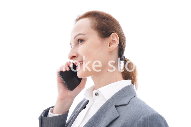 スマートフォンを使うスーツを着たビジネスウーマン