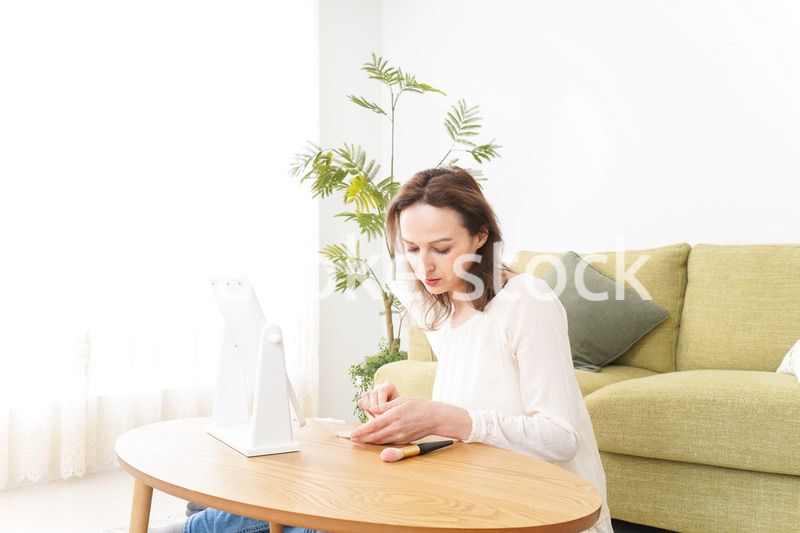自宅で化粧をする若い女性