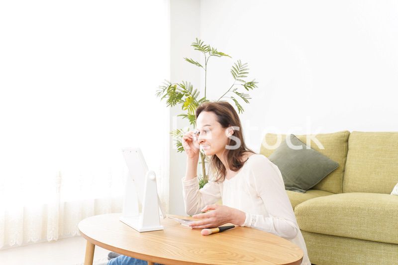 自宅で化粧をする若い女性