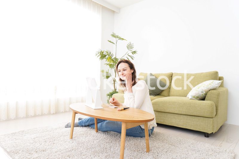 自宅で化粧をする若い女性