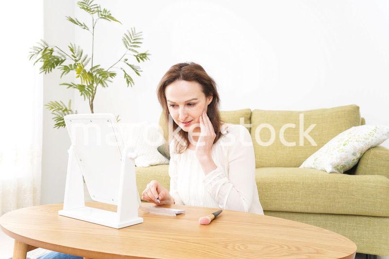 自宅で化粧をする若い女性