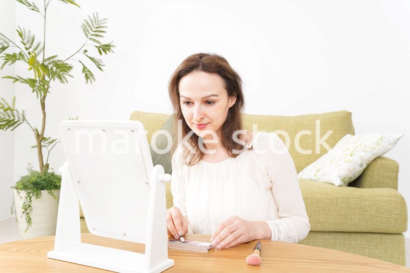 自宅で化粧をする若い女性