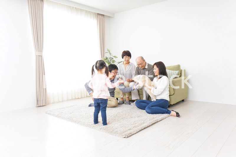 家族で犬と遊ぶ幸せな三世代ファミリー