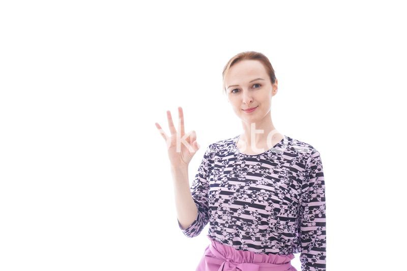 グッドサインをする私服を着た若い女性