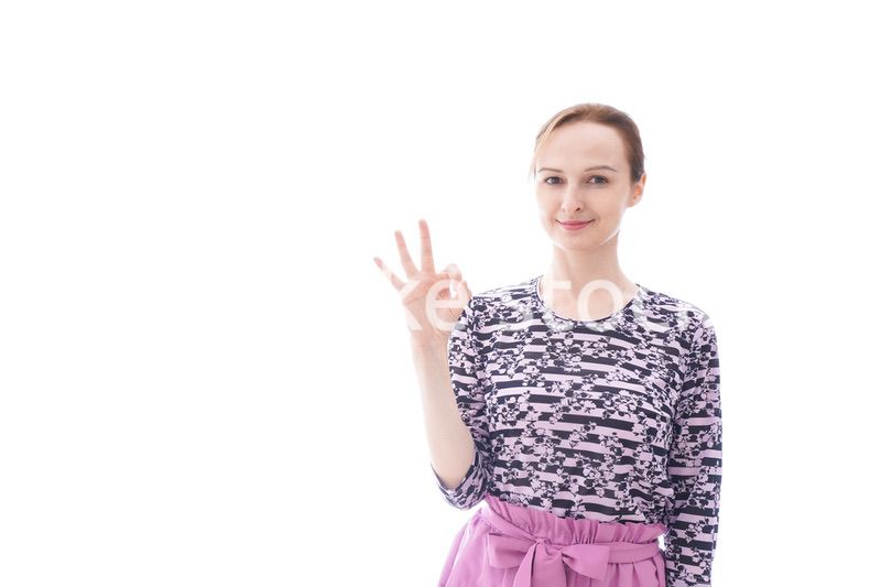 グッドサインをする私服を着た若い女性