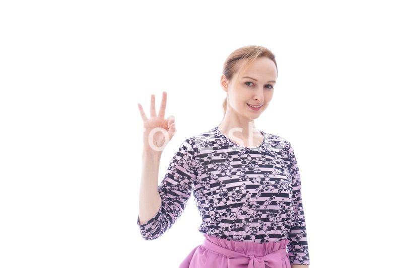 グッドサインをする私服を着た若い女性