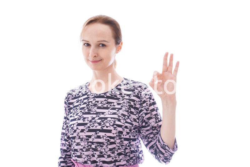 グッドサインをする私服を着た若い女性