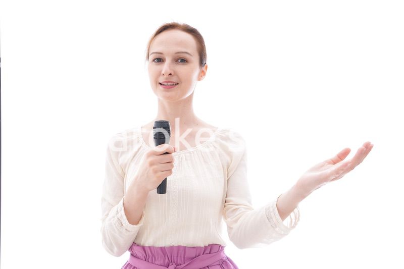 マイクで話す笑顔の若い女性