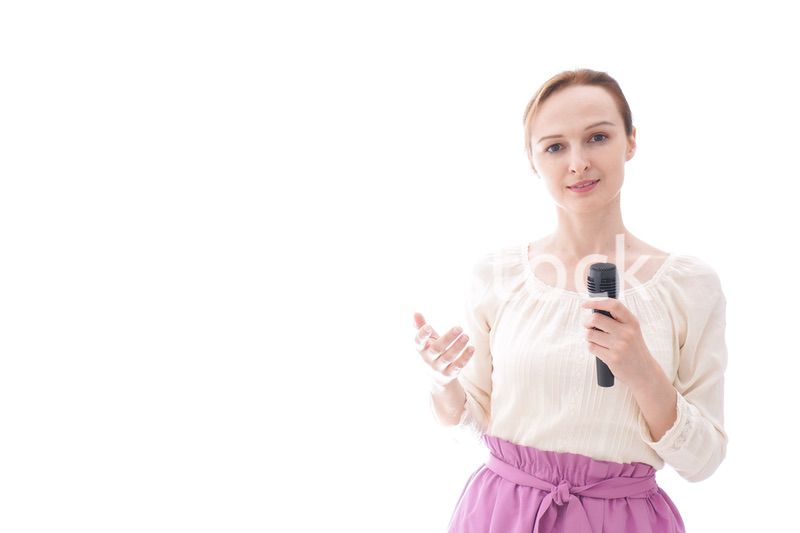 マイクで話す笑顔の若い女性