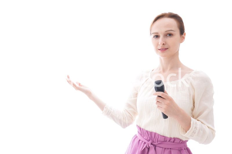 マイクで話す笑顔の若い女性