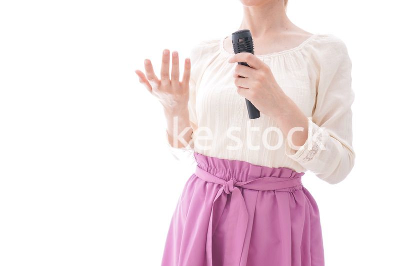 マイクで話す笑顔の若い女性