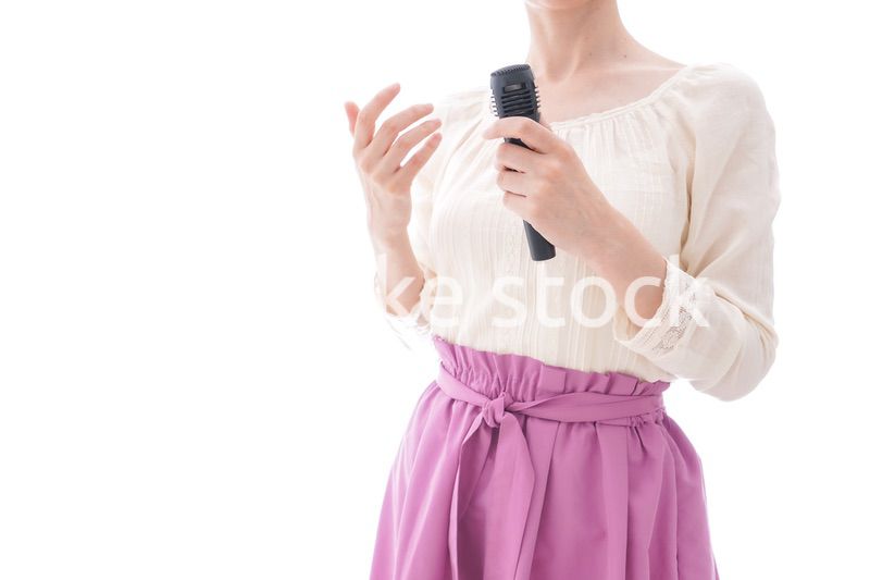 マイクで話す笑顔の若い女性