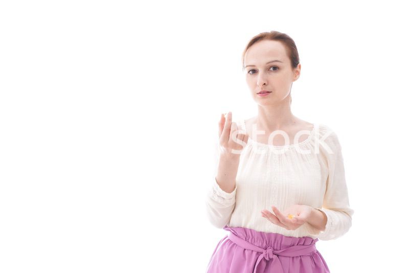 サプリメントを飲む笑顔の若い女性