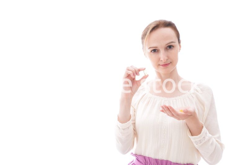 サプリメントを飲む笑顔の若い女性