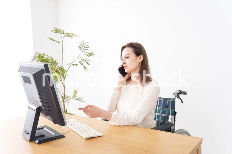 車椅子でデスクワークをする外国人の女性