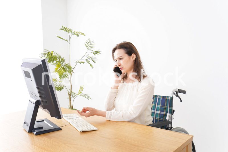 車椅子でデスクワークをする外国人の女性