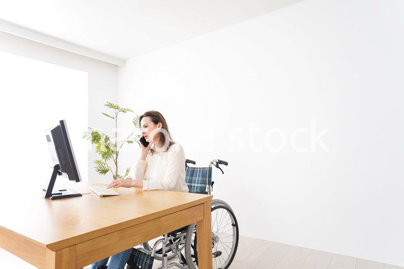 車椅子でデスクワークをする外国人の女性