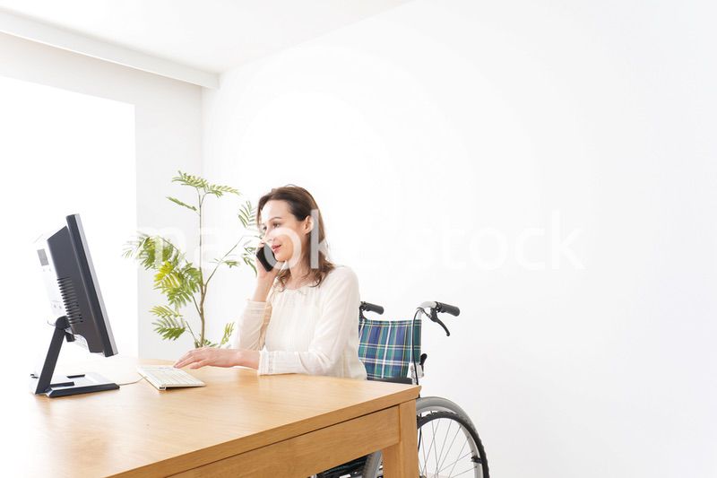 車椅子でデスクワークをする外国人の女性