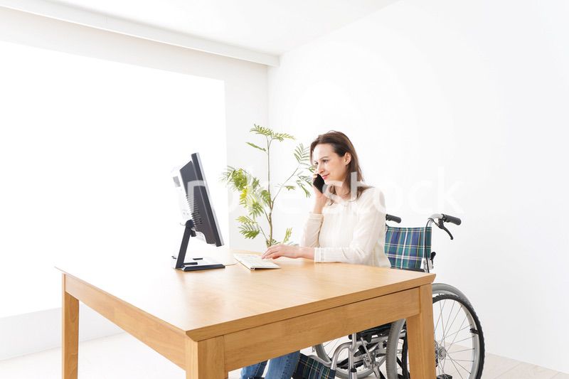 車椅子でデスクワークをする外国人の女性