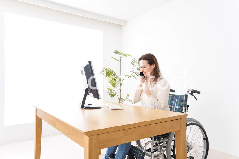 車椅子でデスクワークをする外国人の女性