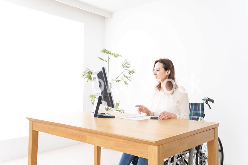 車椅子でデスクワークをする外国人の女性