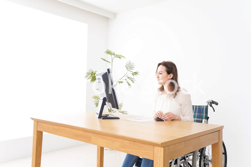 車椅子でデスクワークをする外国人の女性