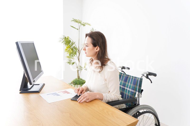 車椅子でデスクワークをする外国人の女性