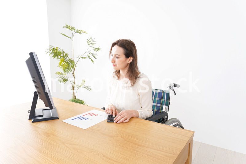 車椅子でデスクワークをする外国人の女性