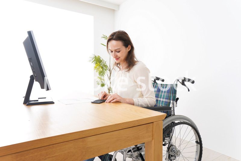 車椅子でデスクワークをする外国人の女性