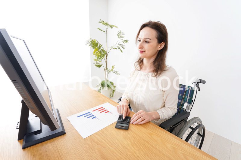 車椅子でデスクワークをする外国人の女性